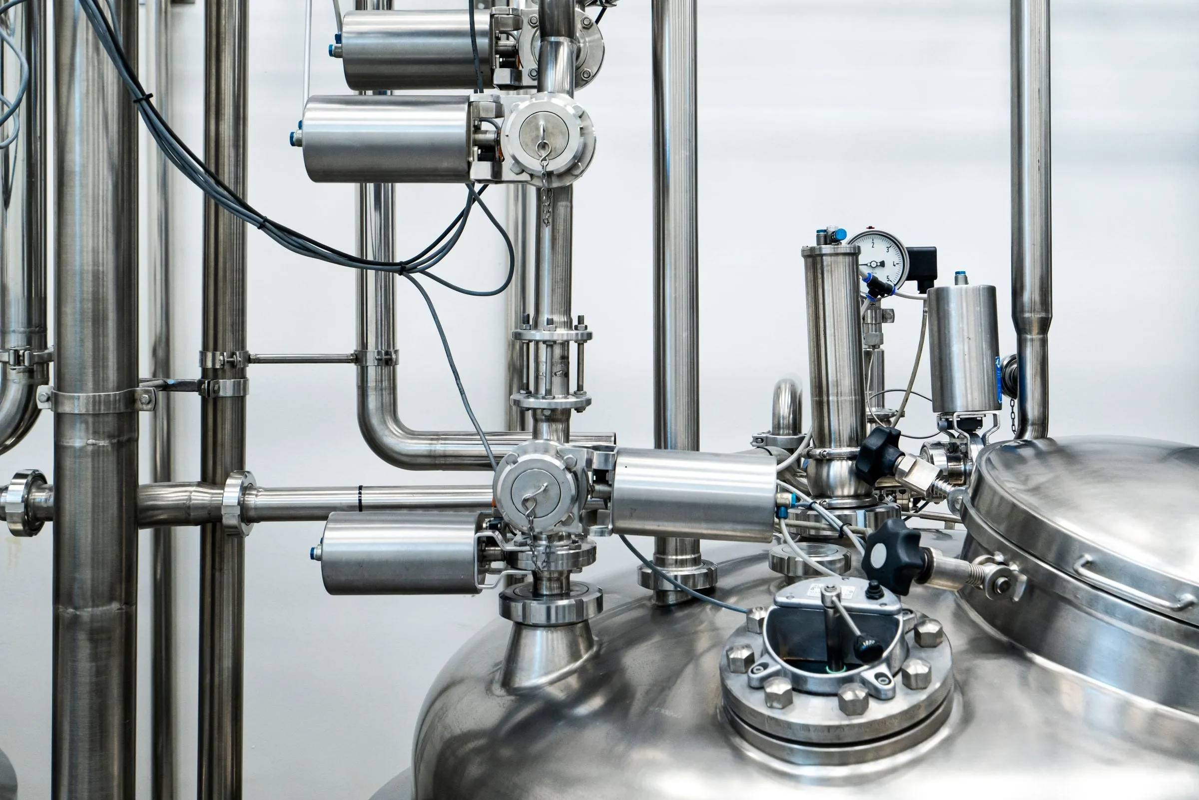 Stainless steel tank, pipes and automated valves in an industrial plant