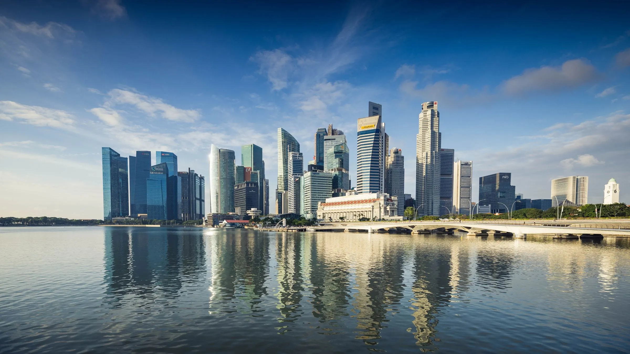 Office towers of Singapore's Marina Bay and Downtown Core reflected in the bay in daylight