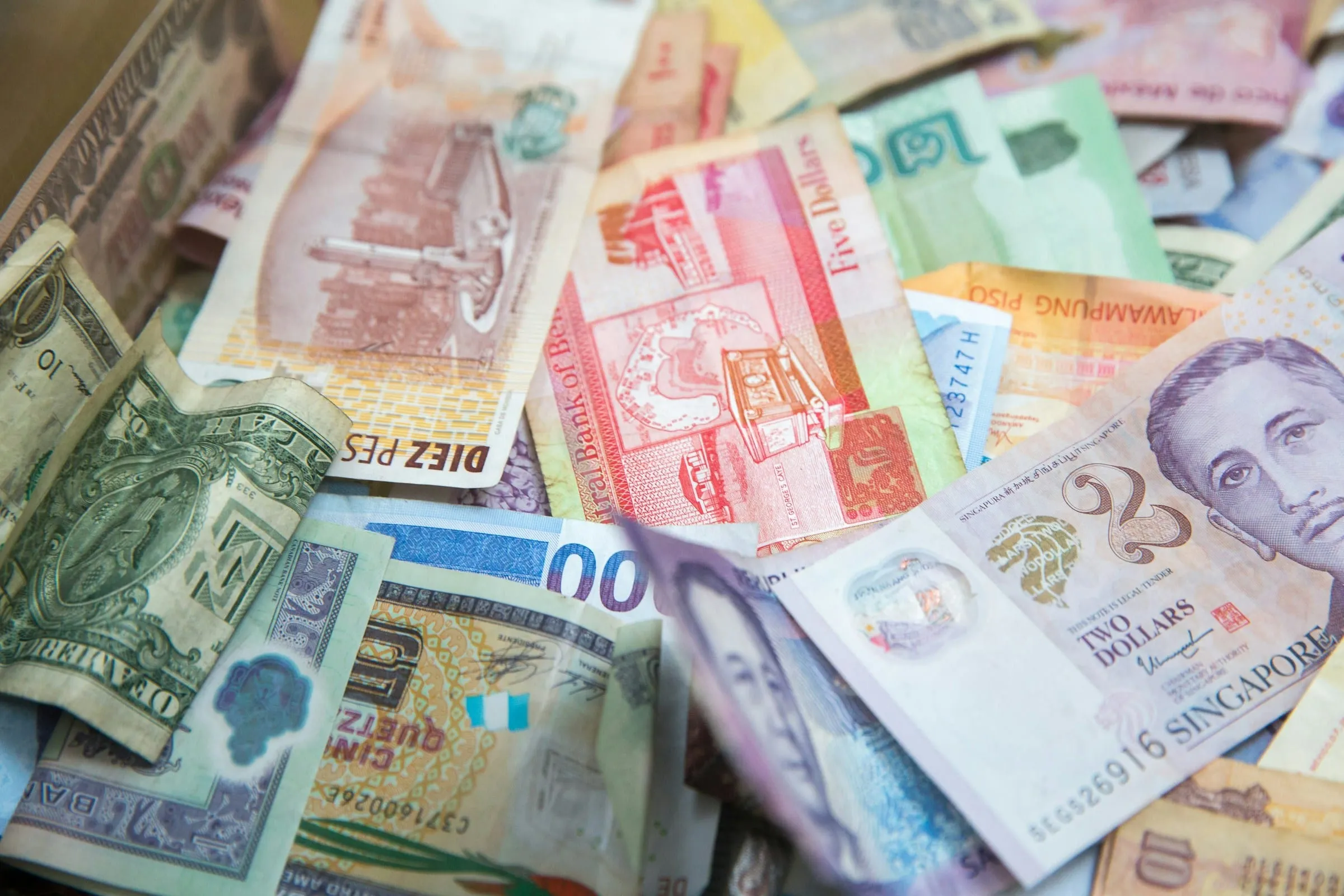 Banknotes from several countries, including a Singapore two-dollar note