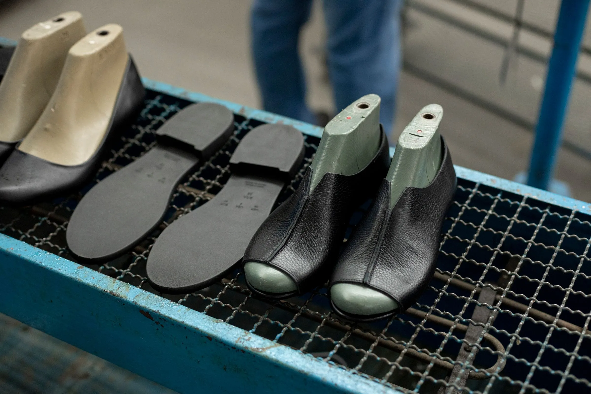 Shoe lasts, soles and leather uppers on a workbench