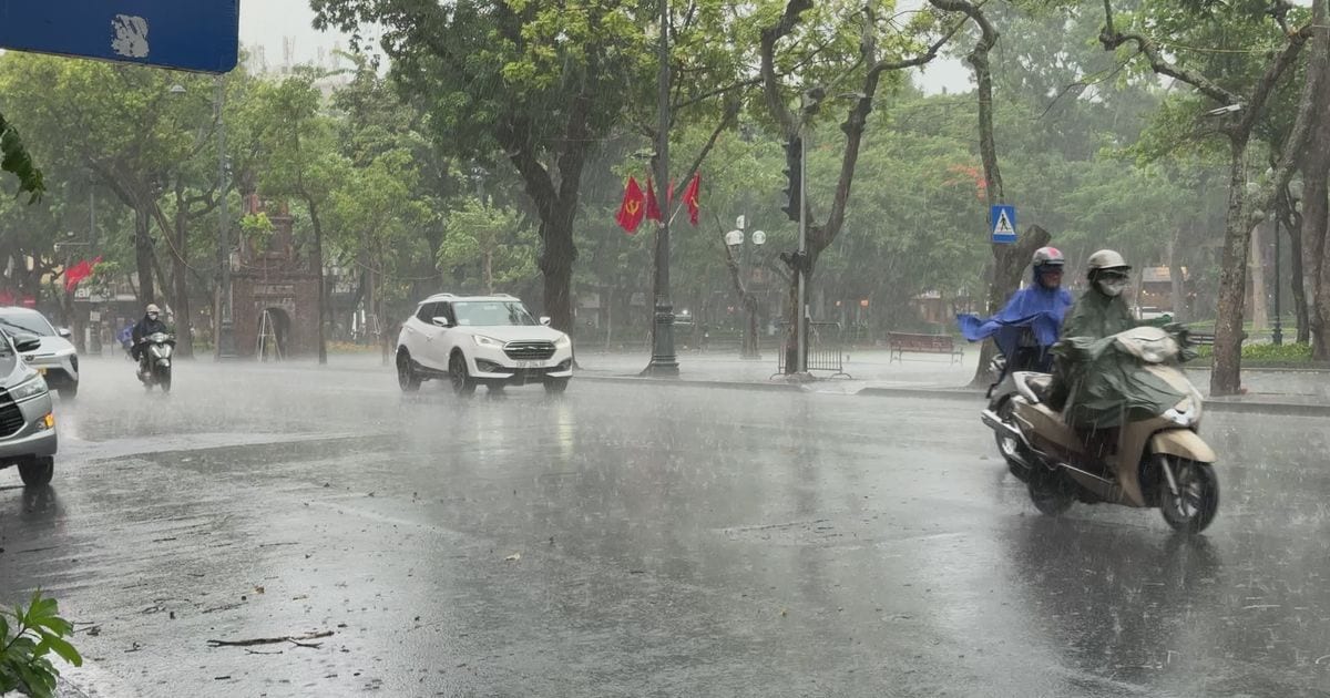 Motorbike and car traffic on a city street in heavy rain